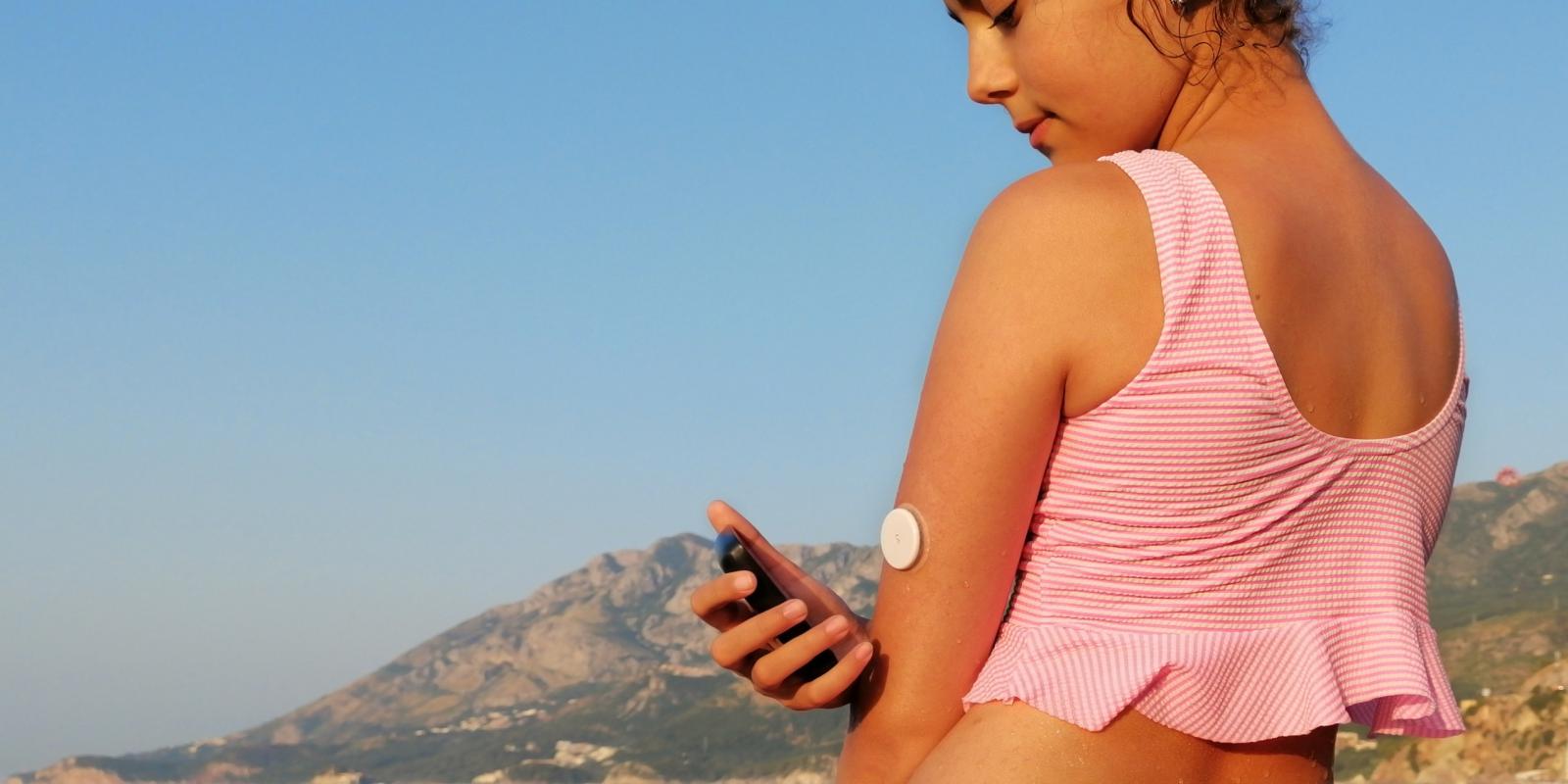 Person at the beach with CGM sensor in their arm